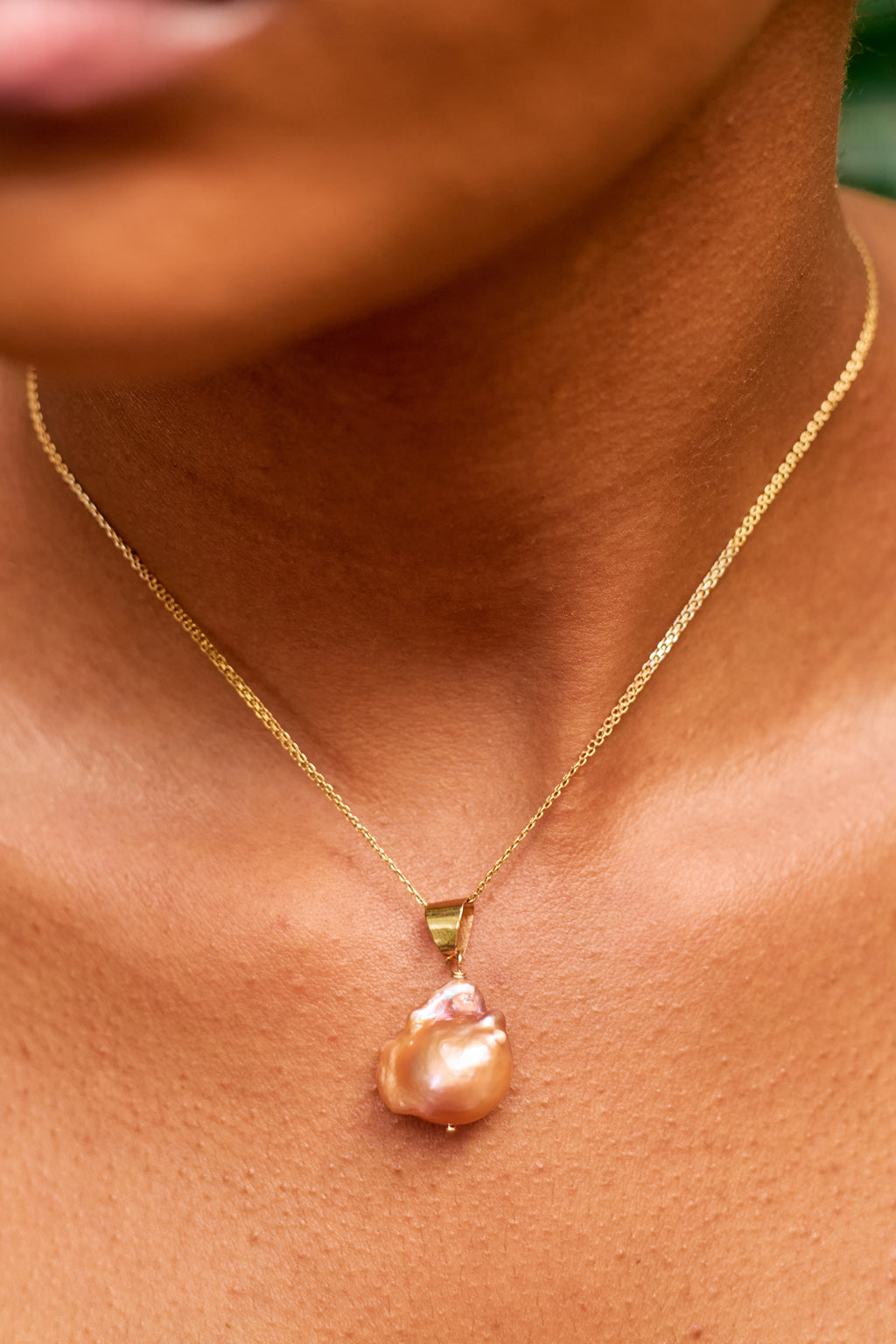 Àsàbí elegant and minimalist necklace featuring a single, genuine Mediterranean coral bead with a premium gold accent and chain.