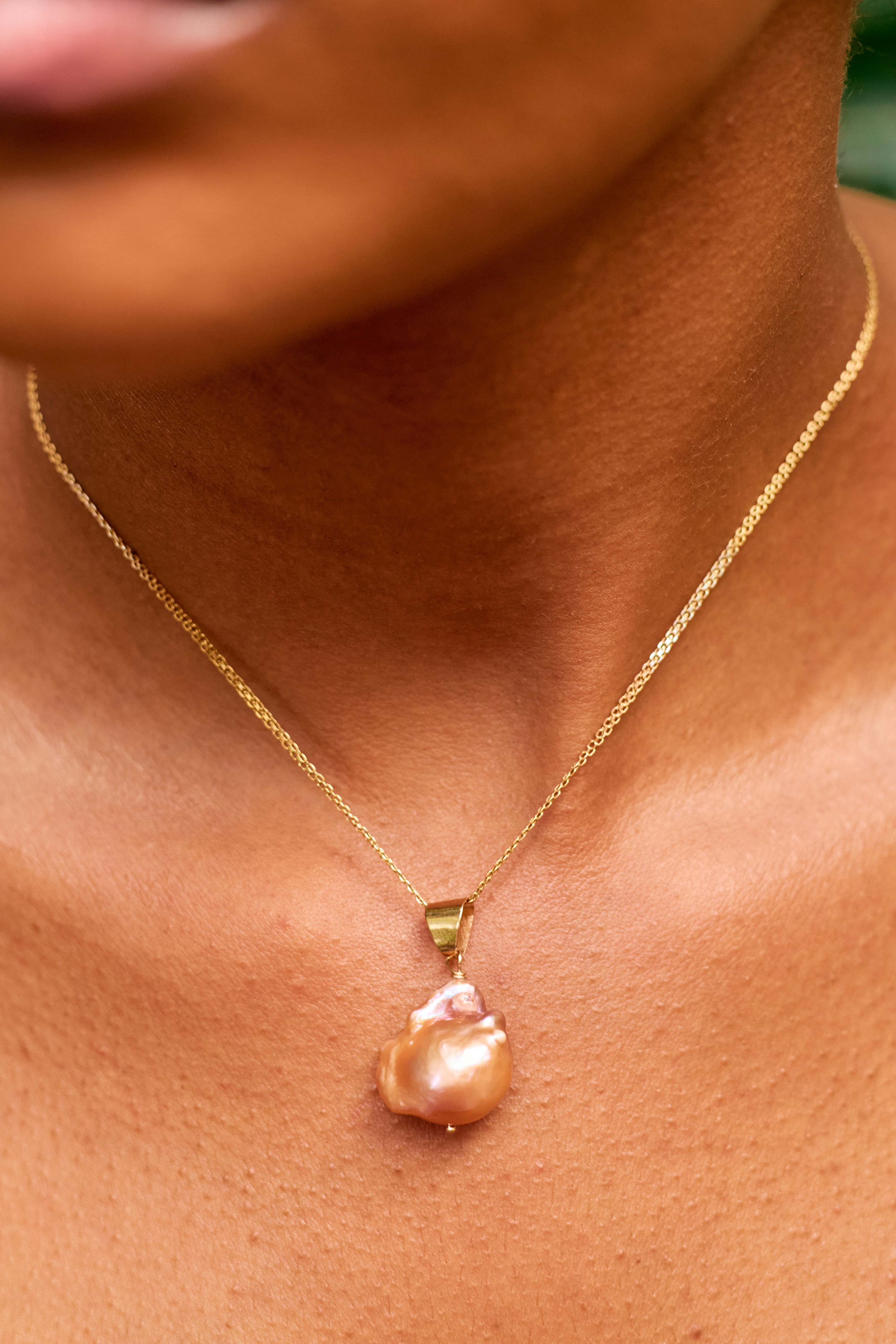 Àsàbí elegant and minimalist necklace featuring a single, genuine Mediterranean coral bead with a premium gold accent and chain.